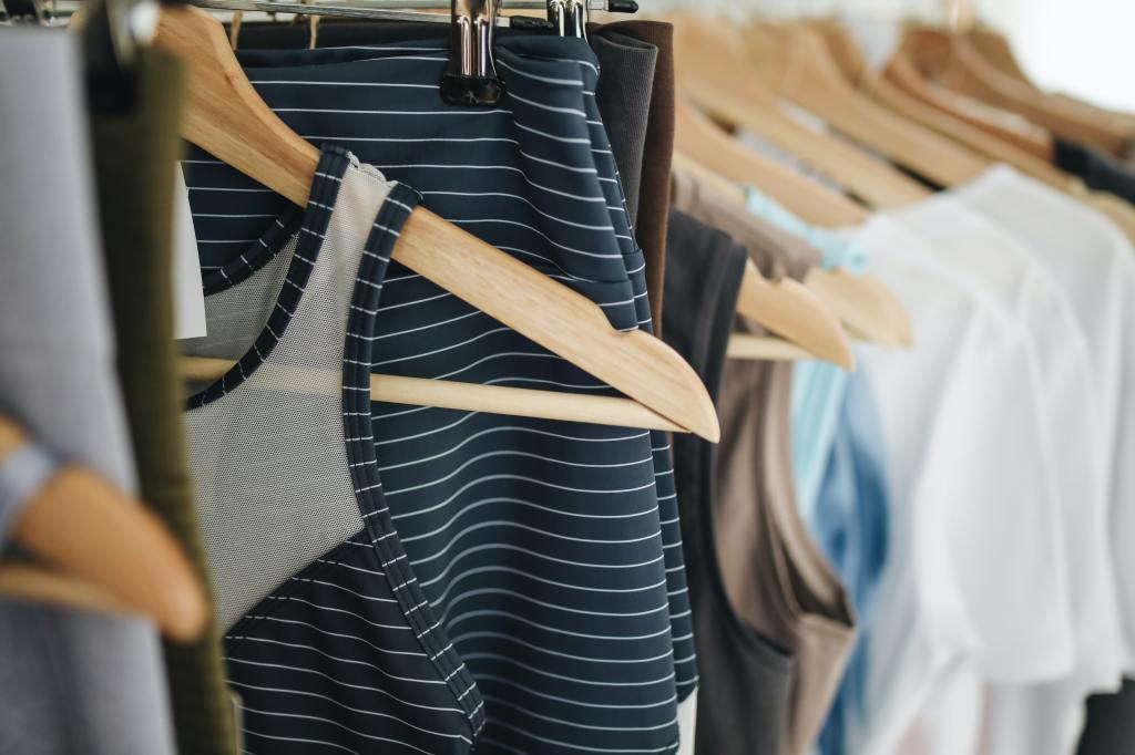 Photo of clothes hung up in a closet on wooden hangers
